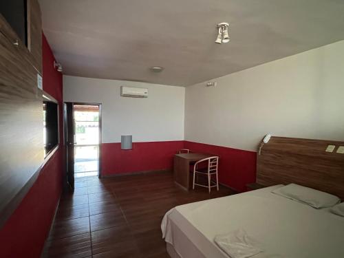 a bedroom with a bed and a table and a chair at Park Motel in Pará de Minas