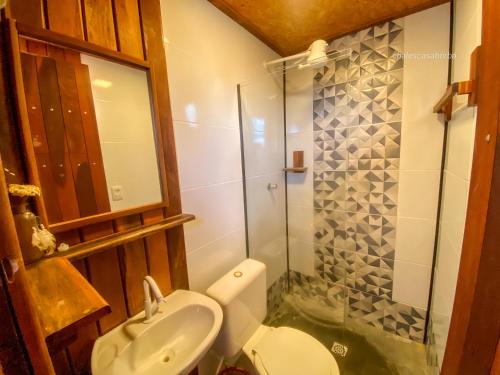 a bathroom with a toilet and a glass shower at Casa Borba Chalé Rústico in Alto Paraíso de Goiás