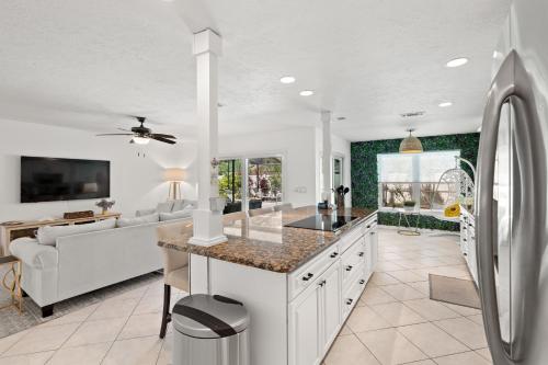 a kitchen with a refrigerator and a living room at Stylish Home near Anna Maria Island Beaches - Heated Pool - Oasis in Bradenton
