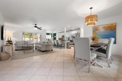 a dining room and living room with a table and chairs at Stylish Home near Anna Maria Island Beaches - Heated Pool - Oasis in Bradenton