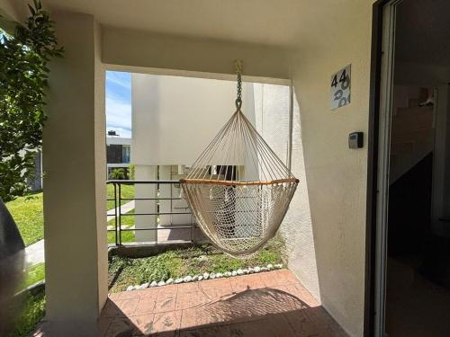 a hammock hanging on the side of a house at CASALUNA frente alberca AirAc in Atlacholoaya