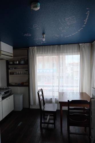 a kitchen with a table and chairs and a window at めくる in Matsumoto