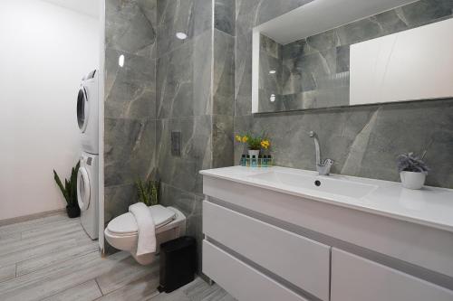 a bathroom with a white sink and a toilet at לוי-קיישן מגוון דירות גן ופנטהאוזים וסוויטות נוף ברחוב הצנחנים in Tiberias
