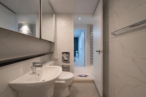 釜山にあるNew Apt 34py 3min to Haeundae Beach LG StanbyMe & Styler Netflix & Sky Capsuleの洗面台とトイレを備えた白いバスルーム
