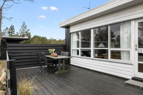 a wooden deck with a table and chairs on it at TV1595-Skagen-Kaeruldvej-23 in Skagen
