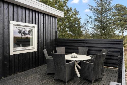 a patio with a table and chairs on a deck at TV1595-Skagen-Kaeruldvej-23 in Skagen