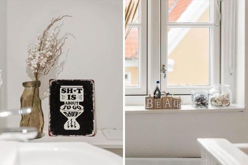 a bathroom counter with a vase with flowers and a window at TV1648-Skagen-Kirkevej-4 in Skagen