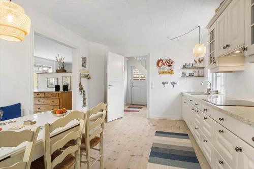 a white kitchen with a table and a dining room at TV1648-Skagen-Kirkevej-4 in Skagen
