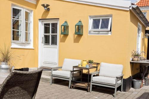 a patio with two chairs and a table in front of a house at TV1648-Skagen-Kirkevej-4 in Skagen