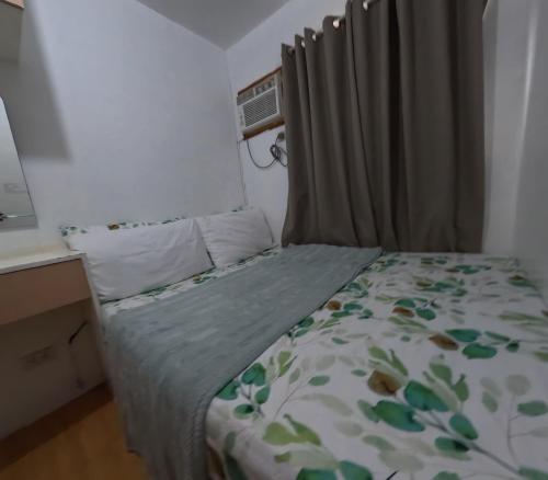 a small bedroom with a bed with a curtain at Cozy 2br deca homes near sm jmall in Mandaue City
