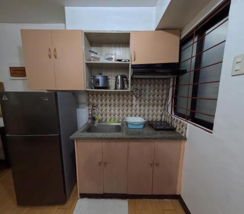 a small kitchen with a sink and a refrigerator at Cozy 2br deca homes near sm jmall in Mandaue City