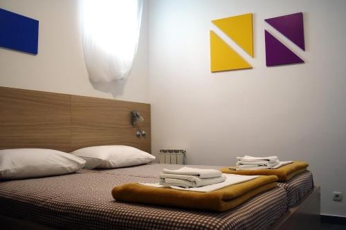 a bedroom with a bed with towels on it at Rooms Fitea in Osijek