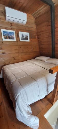 a bedroom with a bed in a wooden wall at Chalé Valentina com Hidro - oktoberfest in Blumenau