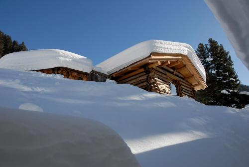 a snow covered log cabin with snow on it at Hotel Ducan in Monstein