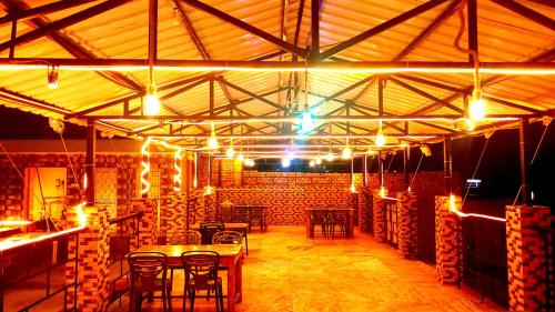 a large room with tables and chairs and lights at Sonargaon Beach Resort in Mandarmoni