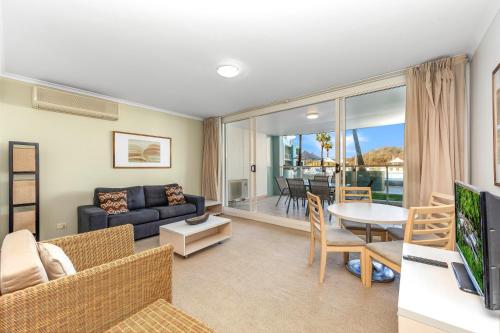 a living room with a couch and a table at Ettalong Beach Luxury Apartments in Ettalong Beach