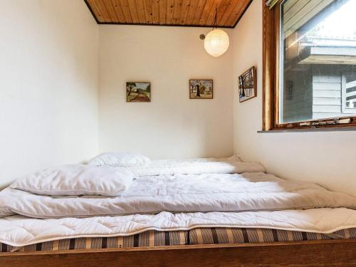 an unmade bed in a room with a window at 6 person holiday home in Øster Assels in Øster Assels
