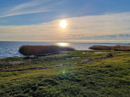 a sun setting over a body of water at 3 person holiday home in Ringkøbing in Ringkøbing