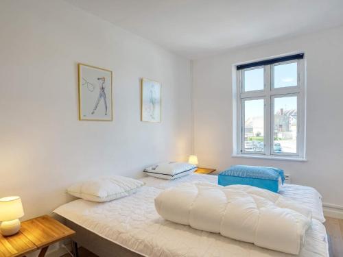 a white bedroom with a large bed with two pillows at 4 person holiday home in Nakskov-By Traum in Nakskov