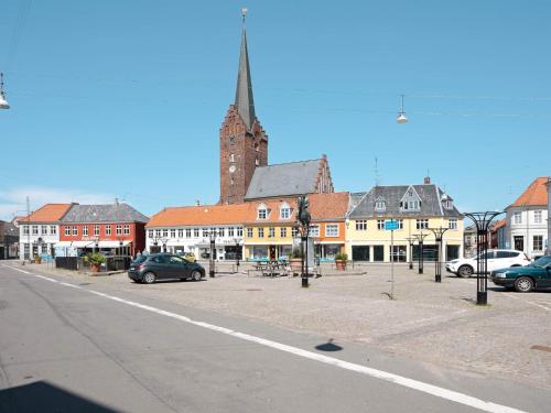 a city street with cars parked in front of a church at 4 person holiday home in Nakskov-By Traum in Nakskov