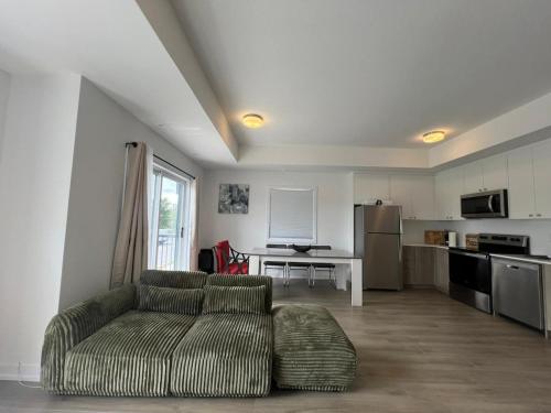 a living room with a couch and a kitchen at Stylish 2-Story Condo with Balcony in Kitchener
