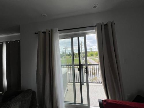 a room with a sliding glass door with a balcony at Stylish 2-Story Condo with Balcony in Kitchener