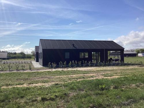 a black house with a solar roof on a field at 5 star holiday home in Ansager in Ansager