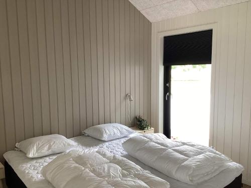 a bed with white sheets and pillows in a bedroom at 5 star holiday home in Ansager in Ansager