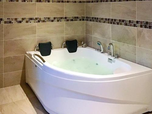a bath tub with two faucets in a bathroom at Tranquil Riverside Retreat in Holstebro