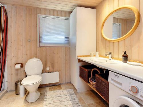 a bathroom with a toilet and a sink and a mirror at 6 person holiday home in Blokhus-By Traum in Blokhus