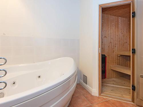 a white bath tub in a bathroom with a shower at 6 person holiday home in Ringkøbing in Ringkøbing