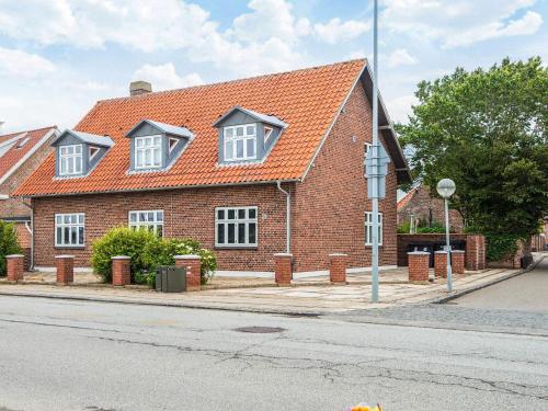 a brick house with an orange roof on a street at Holiday apartment near town square in Ringkøbing