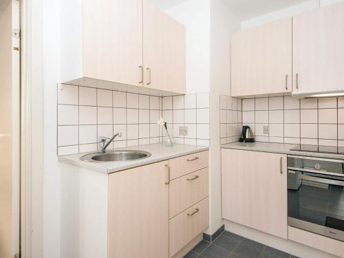 a kitchen with white cabinets and a sink at Holiday apartment near town square in Ringkøbing