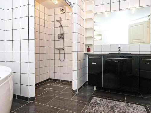 a white tiled bathroom with a shower and a sink at Holiday home in Ebeltoft with roof terrace in Ebeltoft
