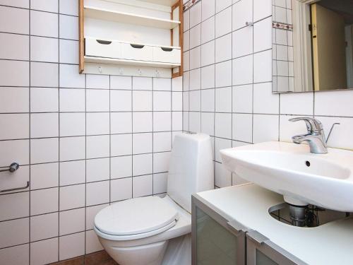 a white bathroom with a toilet and a sink at Charming Retreat in Ringkobing in Ringkøbing