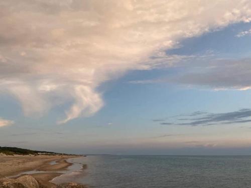 a beach with a cloudy sky and the ocean at 10 person holiday home in Tisvildeleje in Tisvildeleje