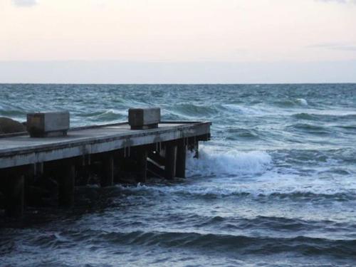 a pier in the middle of the ocean with waves at 10 person holiday home in Tisvildeleje in Tisvildeleje