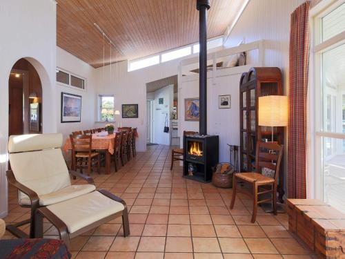 a living room with a fireplace and a table and chairs at 10 person holiday home in Tisvildeleje in Tisvildeleje