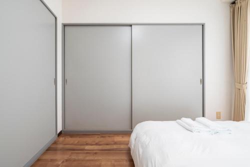 two sliding doors in a bedroom with wood floors at Alice in Maruyama 円山公園近く マーケットすぐ in Sapporo