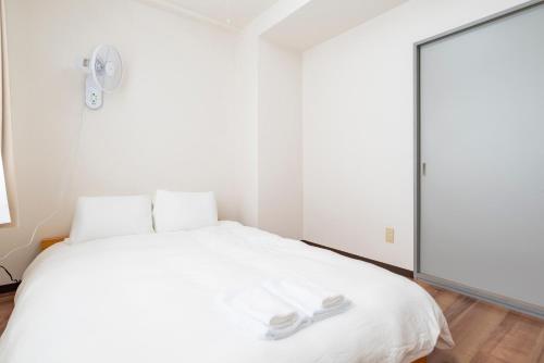 a bedroom with a white bed and a large mirror at Alice in Maruyama 円山公園近く マーケットすぐ in Sapporo