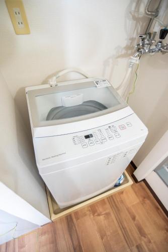 a washing machine in the corner of a room at Alice in Maruyama 円山公園近く マーケットすぐ in Sapporo