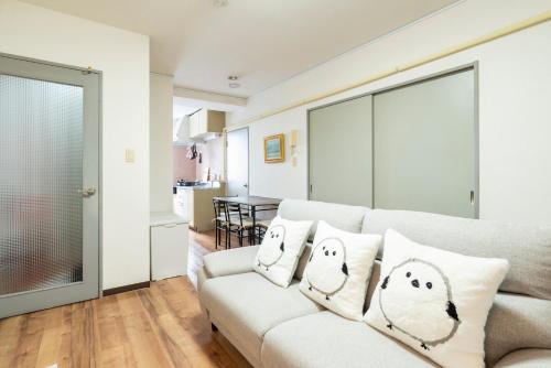 a living room with a couch with pillows on it at Alice in Maruyama 円山公園近く マーケットすぐ in Sapporo