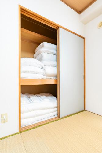 a sliding glass door leading into a room with towels at Alice in Maruyama 円山公園近く マーケットすぐ in Sapporo