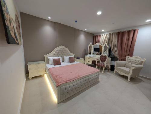 a bedroom with a bed and a chair and a mirror at Premium Guest House - Pentasquare in Lahore