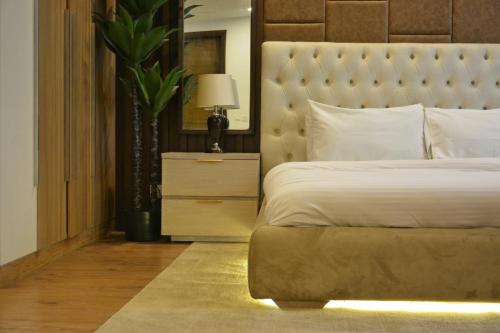 a bedroom with a large bed with a large headboard at Premium Guest House - Pentasquare in Lahore