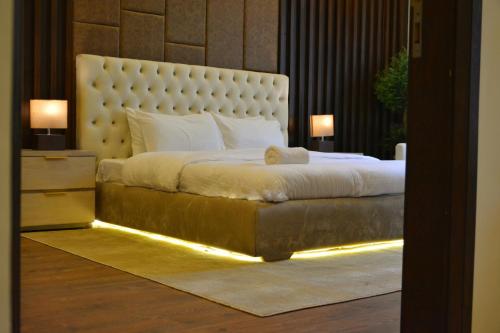 a bedroom with a large bed with a large headboard at Premium Guest House - Pentasquare in Lahore
