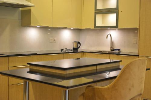 a kitchen with a counter with a sink in it at Premium Guest House - Pentasquare in Lahore
