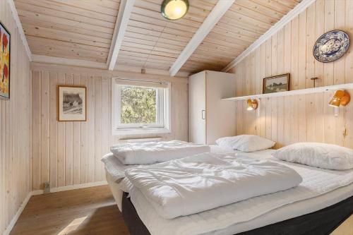 two beds in a room with wooden walls at TV1660-Albaek-Lyngstien-6-A in Ålbæk