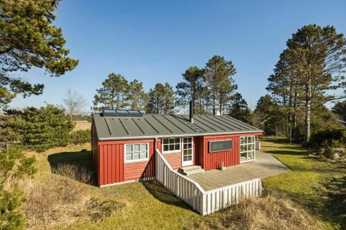 a red tiny house in the middle of a field at TV1652-Albaek-Musvagevej-116 in Ålbæk