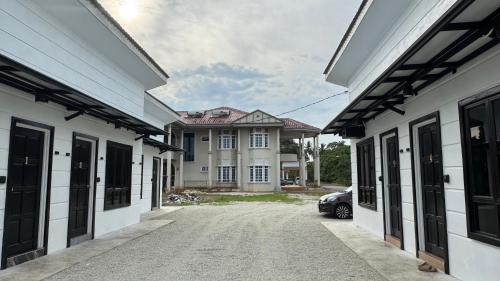 a house with a car parked between two buildings at D'villa roomstay tangkak in Tangkak